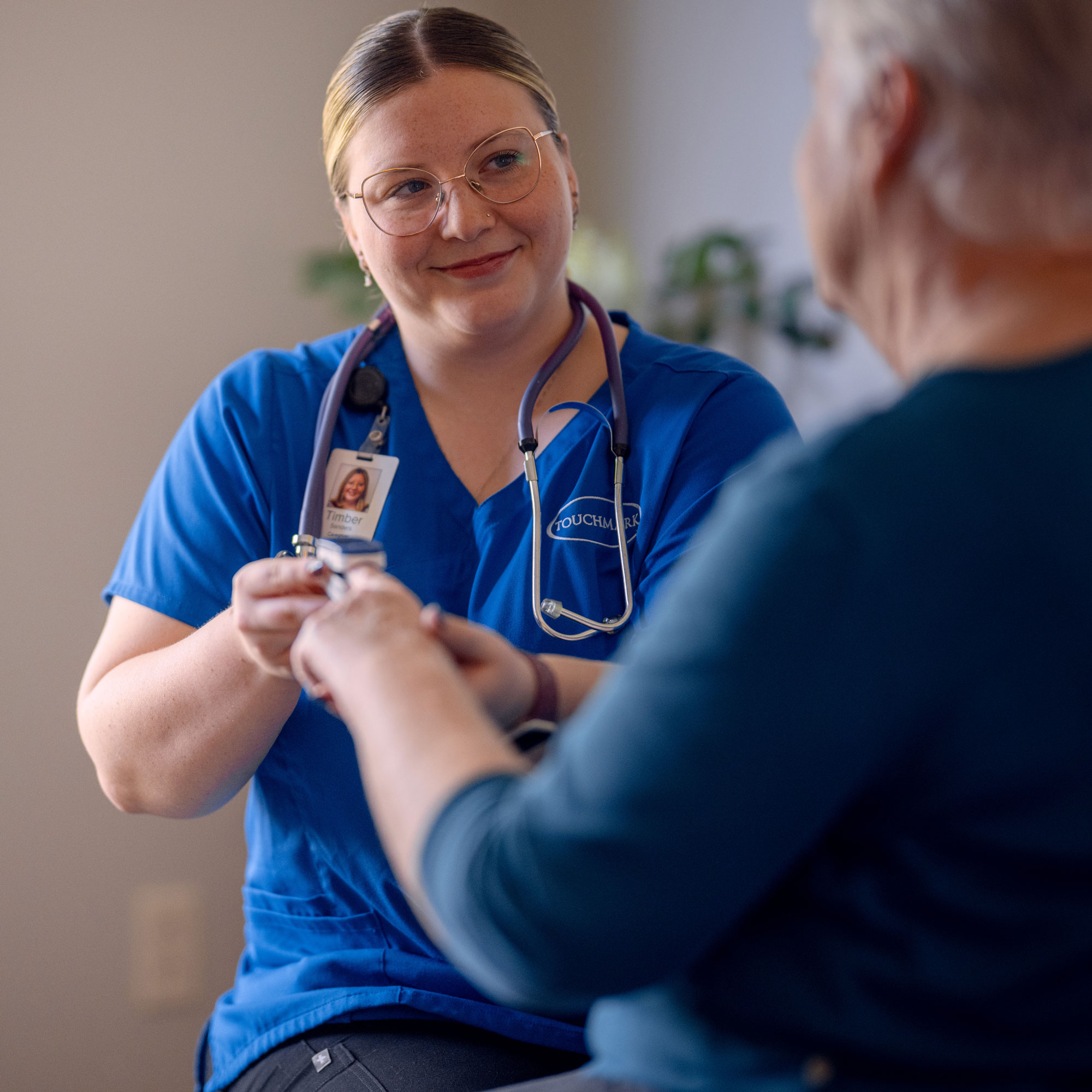 Nurse taking residents blood pressure.